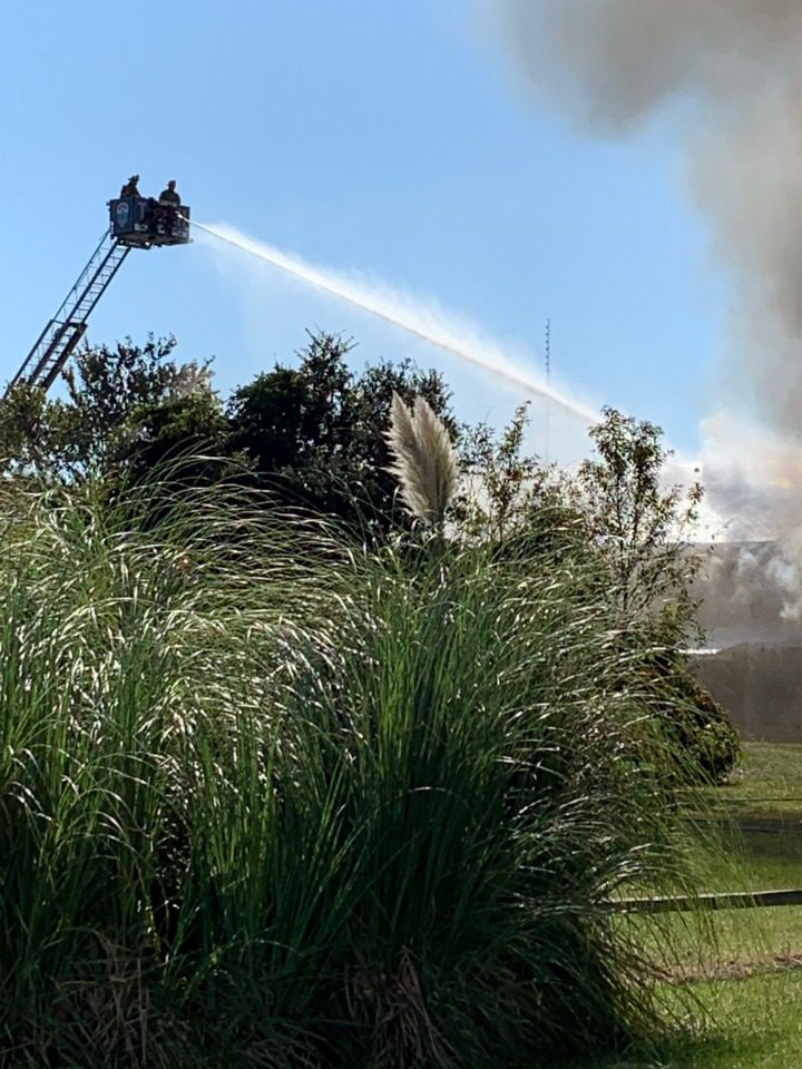 Firefighters spraying roof flames