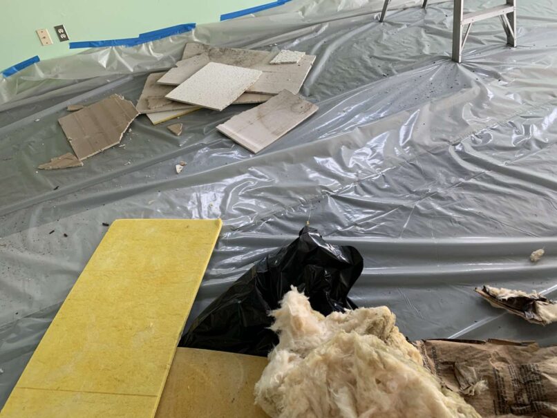debris from ceiling removal is contained on prepped floor for disposal