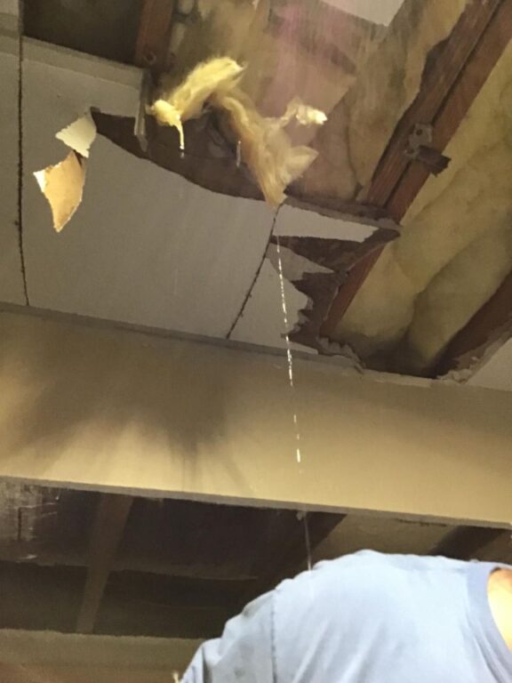 Water drains from ceiling where water tank is stationed on upper floor